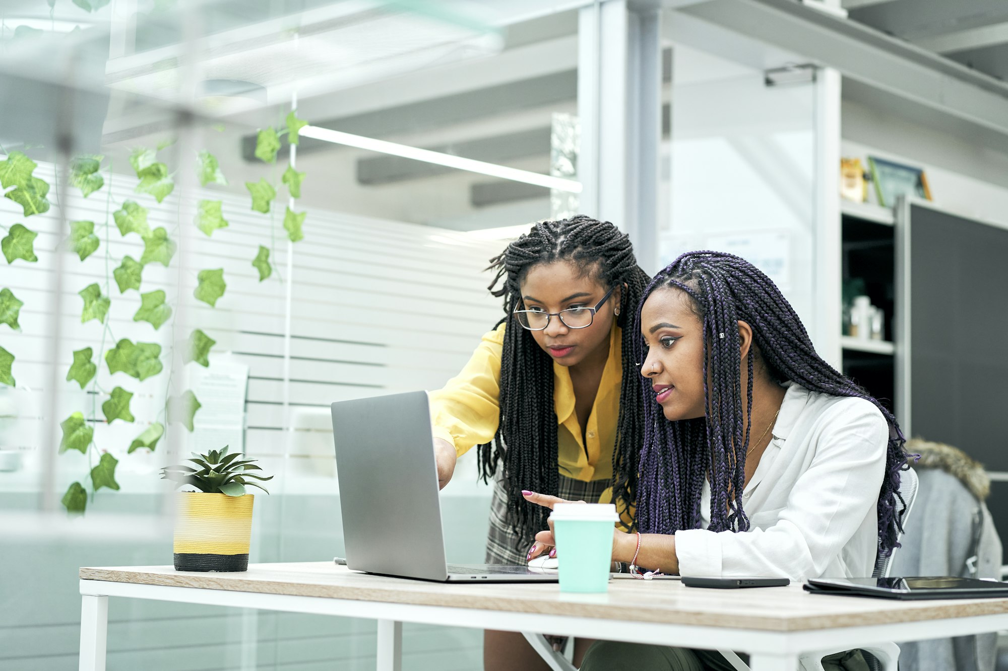 Female co-workers in the office discussing marketing strategies, reviewing analytical