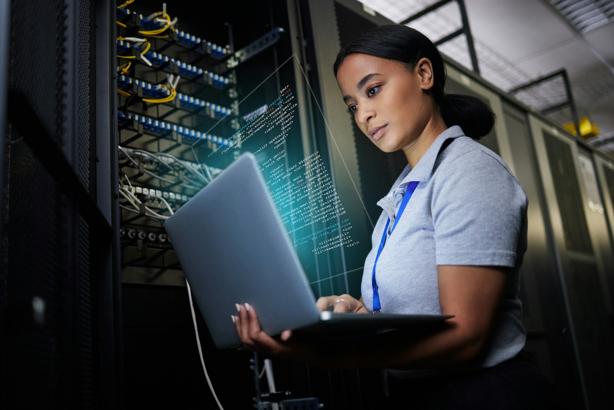 Laptop, network and data center with a black woman it support engineer working in a dark server roo