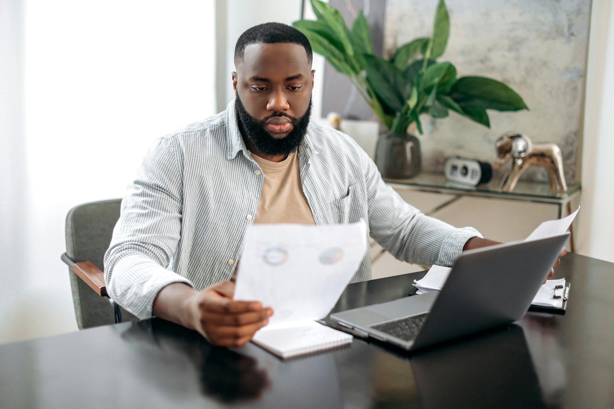 Serious concentrated successful african american busy man, freelancer or company ceo, working with