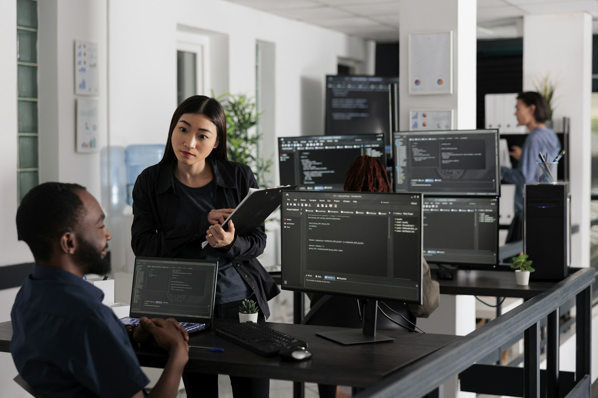 Team of system engineers working on software development with source code